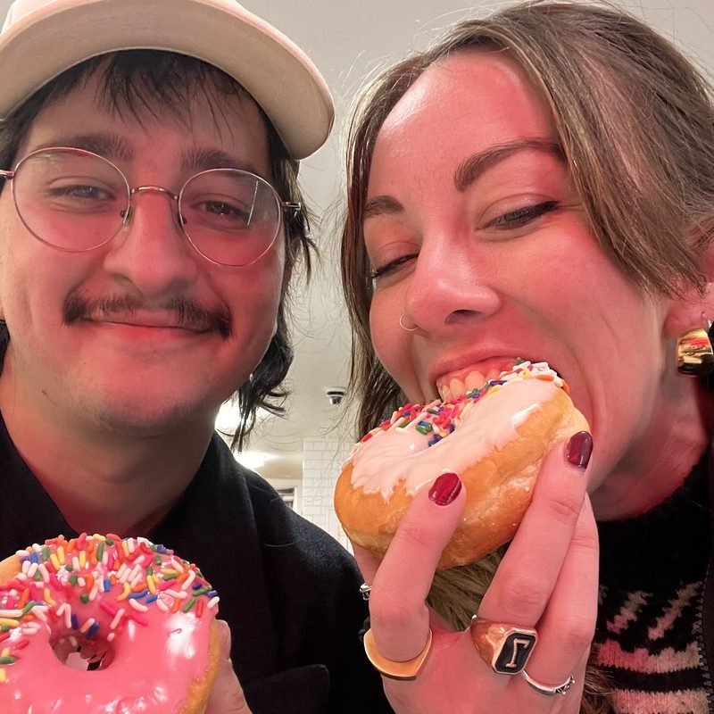 Simón and Tracy sharing a big sprinkled donut