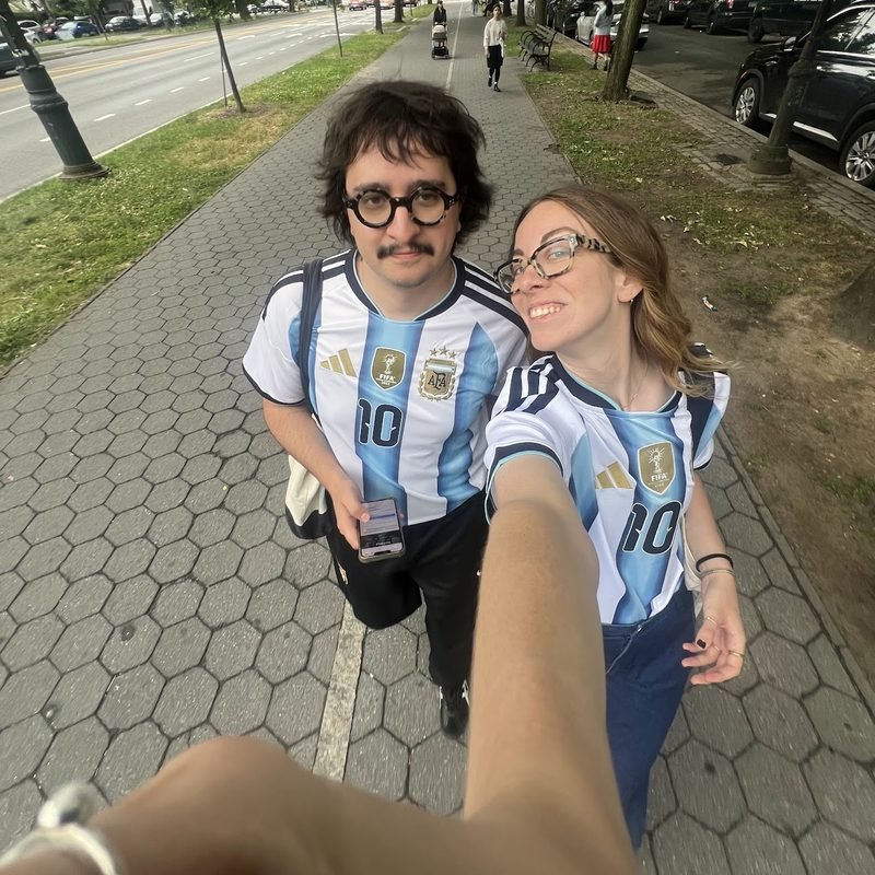 Simón and Tracy in Argentina jerseys on a tree-lined path