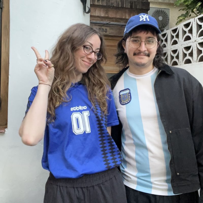 Simón and Tracy in jerseys, one making a peace sign