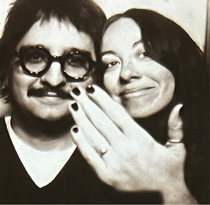 Simón and Tracy in a photo booth, Tracy showing off her ring